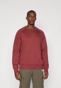 Marlot crew-neck sweatshirt med raglanærmer, ribbede manchetter og kant. Har et diskret logo på venstre bryst. Materialet ser blødt og struktureret ud.