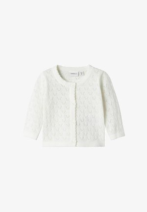 Cardigan en tricot blanc avec un motif en diamants, des bords festonnés et cinq boutons à l'avant. Manches longues, matériau léger.