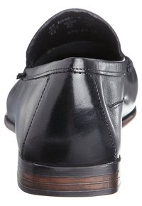 Mocassins en cuir noir avec une finition lisse, bout rond, détails cousus et un talon en bois brun. La vue arrière met en avant la silhouette élégante.