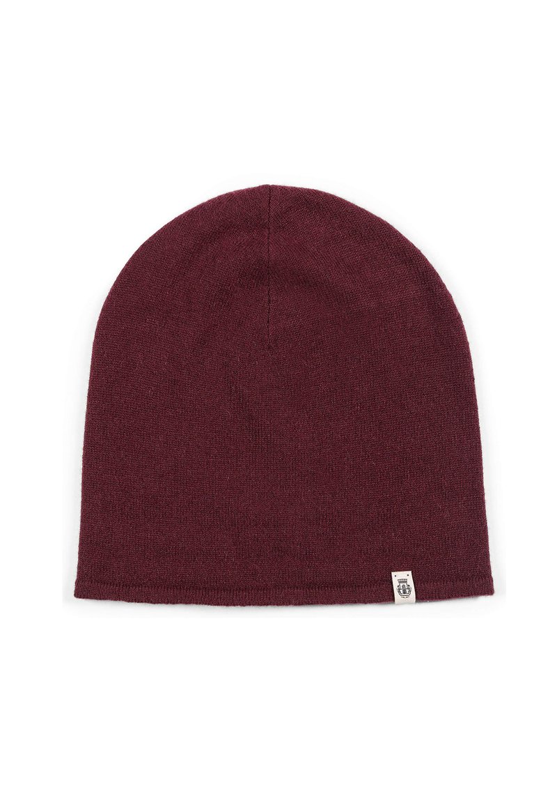 Maroon knitted beanie hat with small beige label on bottom edge, displayed flat on white background.