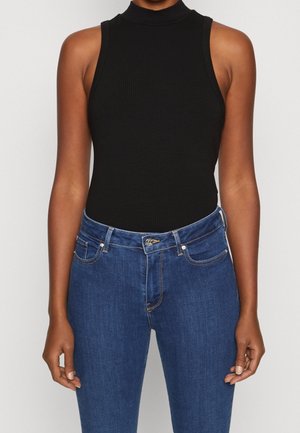 Sort ribbet tank bodysuit med høj hals, parret med blå denim jeans med knaplukning og subtile syninger.