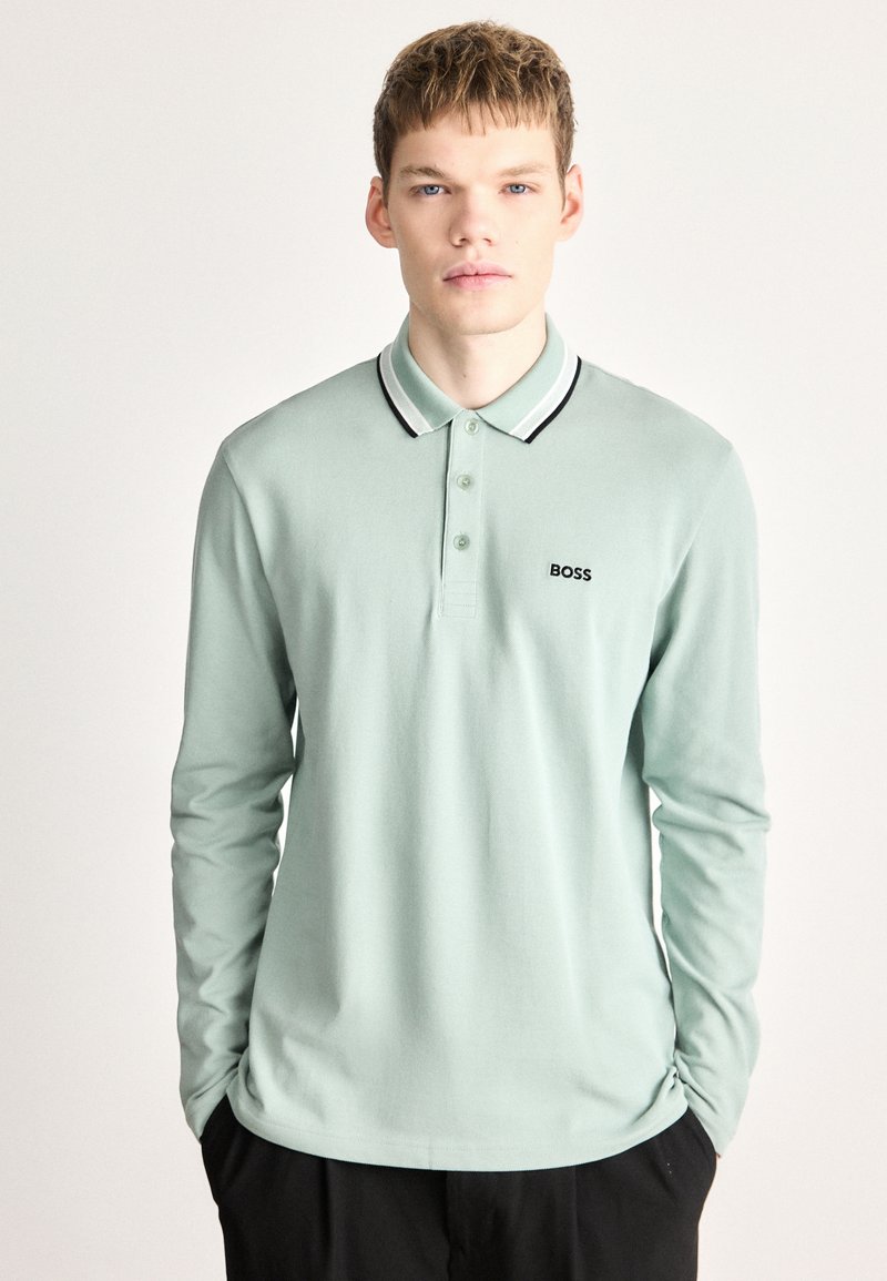 Polo de manga comprida em algodão verde menta com gola riscada preta e branca, apresentando um pequeno logo preto "BOSS" no peito.