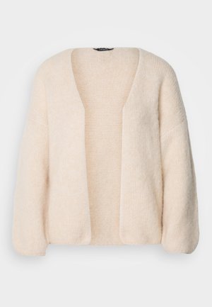 Light beige oversized cardigan made of soft, textured knit fabric. Open front with wide sleeves and no fastenings.
