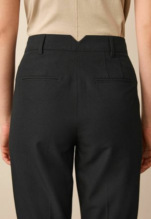 Zwarte pantalons met een getailleerde pasvorm, met een V-vormig ontwerp aan de achterkant, twee achterzakken en een gladde stof met een lichte glans.