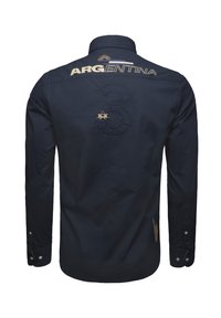 Camisa de manga larga en color navy con el bordado "ARGENTINA" y el número "3" en la parte trasera, con puños abotonados y una tela texturizada.