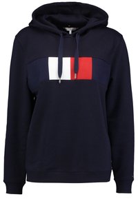 Námořnická mikina s barevně členěnou hrudní částí skládající se z bílých, červených a modrých sekcí. Šňůrky s kovovými konci, žebrované manžety a lem. Měkčená tkanina.