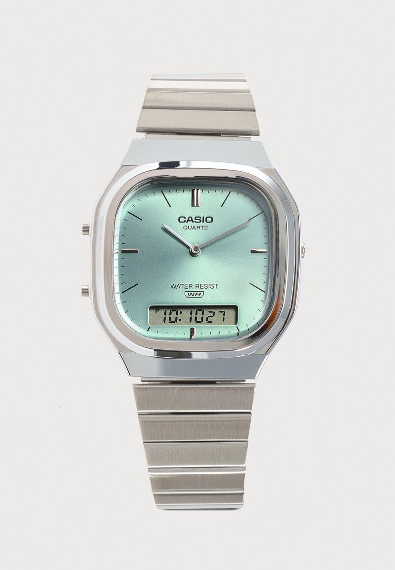 Montre-bracelet Casio quartz avec bracelet en acier inoxydable, cadran analogique bleu clair, résistante à l'eau, et affichage numérique de l'heure en bas au centre.