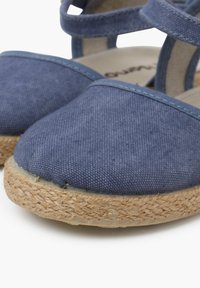 Modré látkové espadrilky s tkanou juteovou podrážkou, kulatou špičkou a designem s křížovými popruhy. Texturovaný materiál s viditelnými švy.