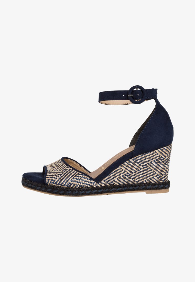 Navy blue wedge sandal with woven patterned straw upper, open toe, ankle strap with buckle, and braided jute sole.