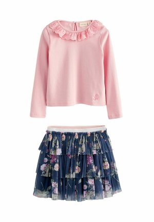Rosa Langarmshirt mit einem Spitzenvolant am Ausschnitt und einem marineblauen Tulrock mit Blumenmuster und geschichteten Rüschen, mit elastischem Bund.