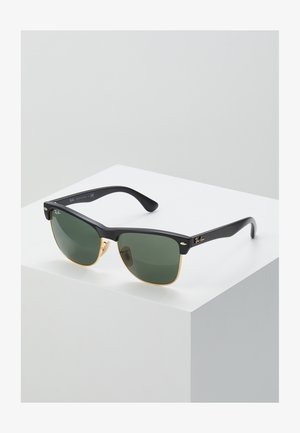 Ray-Ban napszemüveg zöld lencsékkel, fekete műanyag kerettel és arany díszítéssel a széleken. Négyzet alakú, matt felülettel.