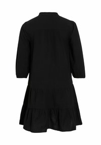 Melna kleita līdz ceļiem ar trīs ceturtdaļu piedurknēm, pakāpenisku apakšmalu un apaļu apkakli. Izgatavota no viegla auduma ar gludu tekstūru.