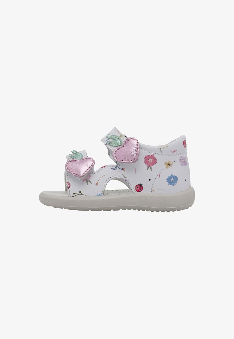 Weiße Sandale mit floralem Muster, pinken metallischen Herzakzenten und grünen Blattdetails. Velcro-Riemen und eine hellgraue Gummisohle.