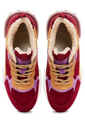 Red, purple, and tan suede sneakers with beige laces, white soles, and thick cream-colored fleece lining visible inside.