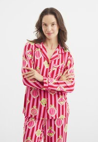 Conjunto de pijama a rayas rosas con grandes patrones decorativos en verde y amarillo. Tejido suave con un corte relajado y diseño de botones.