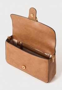 Tan leren handtas met een gladde textuur, klepsluiting en goudkleurige hardware. Het interieur bevat een ritsvak en biedt voldoende opbergplaats.