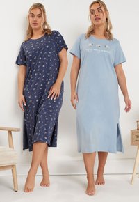 Kaksi naista yöpukusissa: laivastonsinisessä kukkakuosi ja sinisessä brodeeratulla tekstillä. Molemmissa on lyhyet hihat ja polvenmittainen leikkaus.