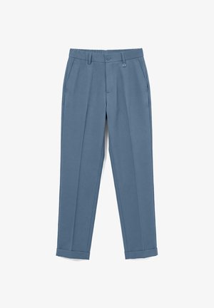 Pantalones azules a medida con bolsillos delanteros, trabillas para cinturón, cierre de botones y bajos con puños, mostrados extendidos sobre fondo blanco.