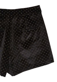 Pantaloni corti di velluto nero con pois dorati e una piccola tasca sul retro su sfondo bianco.