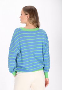 Übergroßer, gestreifter Pullover in Blau und Grün, mit Rundhalsausschnitt und geripptem Saum. Weiche Textur, lockere Passform und fallende Schultern.