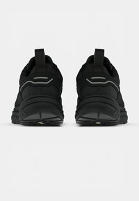 Sapatos de desporto pretos com um design robusto, tecido texturizado, detalhes refletivos e uma sola de borracha com um padrão de tração.