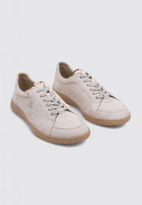 Zapatillas de ante beige claro con acabado suave, suela de goma, puntera redonda y cierre con cordones. Presentan un diseño sutilmente cosido y un acento naranja.