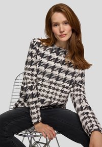 Langarmpullover mit Hahnentrittmuster in Schwarz, Weiß und Grau, mit lockerem Schnitt und strukturierter Stoffqualität.