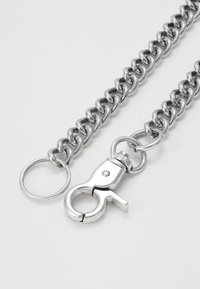 Metal lenke armbånd med en blank sølvfinish, som har sammenkoblede lenker, en vridbar krok og en rund festering.