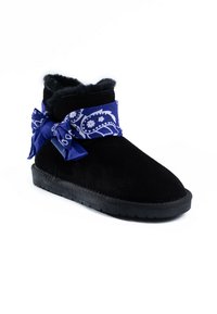 Bota de tobillo de ante negra con un interior suave y esponjoso, y una bufanda de patrón paisley azul atada en la parte superior, con una suela de goma texturizada.