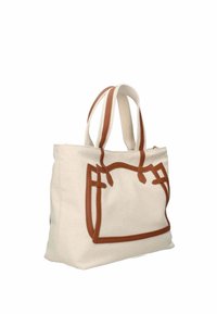 Sac en toile avec des accents en cuir marron, doté de deux poignées solides et d'un design de contour brodé audacieux. Couleur crème clair.