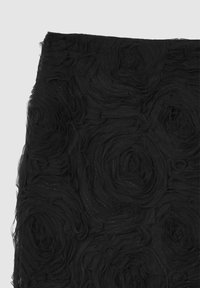 Tessuto nero con motivi di rose stratificate e testurizzate, caratterizzato da una finitura trasparente e una leggera lucentezza. Il design enfatizza profondità e dimensione.