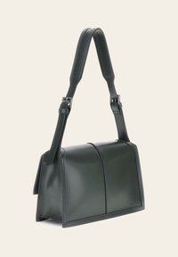 Sac à main en cuir vert foncé au design structuré, avec une base plate, une bandoulière réglable et des détails de couture visibles.