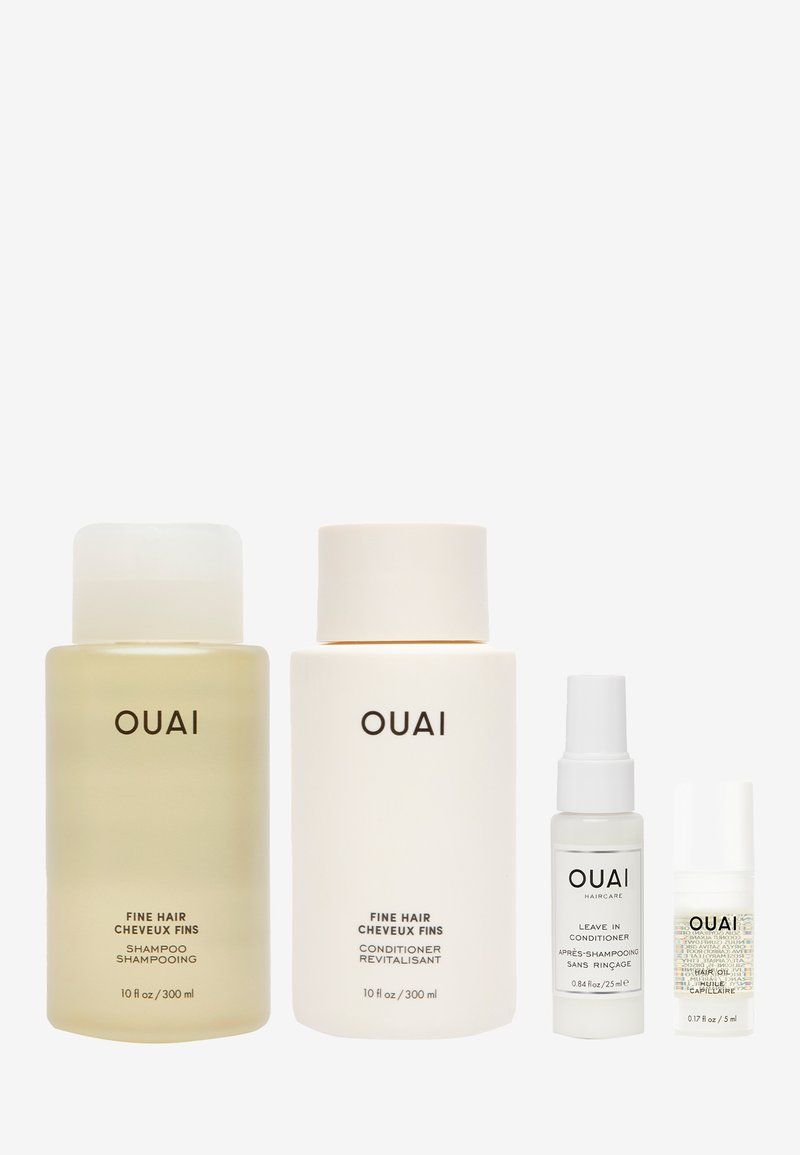 Quatre produits de soins capillaires de OUAI : deux grandes bouteilles en verre étiquetées "Shampooing pour Cheveux Fins" et "Après-shampooing pour Cheveux Fins", toutes deux de 10 fl oz. Deux petites bouteilles spray, l'une étiquetée "Après-shampooing Sans Rinçage" (0,84 fl oz) et l'autre "Huile Capillaire" (0,17 fl oz).