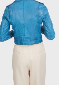 Chaqueta de cuero azul cropped con un acabado texturizado, costuras prominentes y hombreras. La vista trasera muestra un diseño ajustado y bordes suaves.