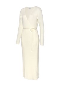 Langes, geripptes cremefarbenes Kleid mit V-Ausschnitt, langen Ärmeln und einem Bindegürtel in der Taille. Es hat eine gerade Silhouette und einen seitlichen Schlitz.