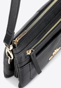 Černá kožená krosbody taška se zlatými zipy a kováním. Obsahuje několik přihrádek a texturovaný povrch. Součástí je nastavitelné ramenní popruhy.