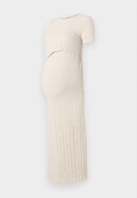 Robe de maternité beige clair côtelée avec manches courtes et un design à panneaux superposés sur le devant, présentant une silhouette ajustée et une longueur longue.