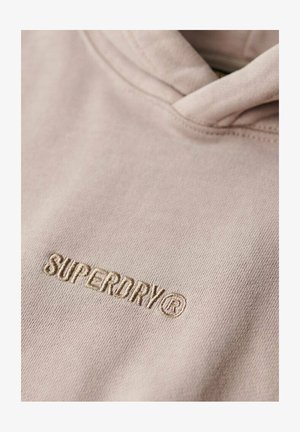 Jasnoróżowa bluza z kapturem wykonana z miękkiego materiału, z haftowanym logo "SUPERDRY®" w dopasowanym kolorze na obszarze klatki piersiowej.