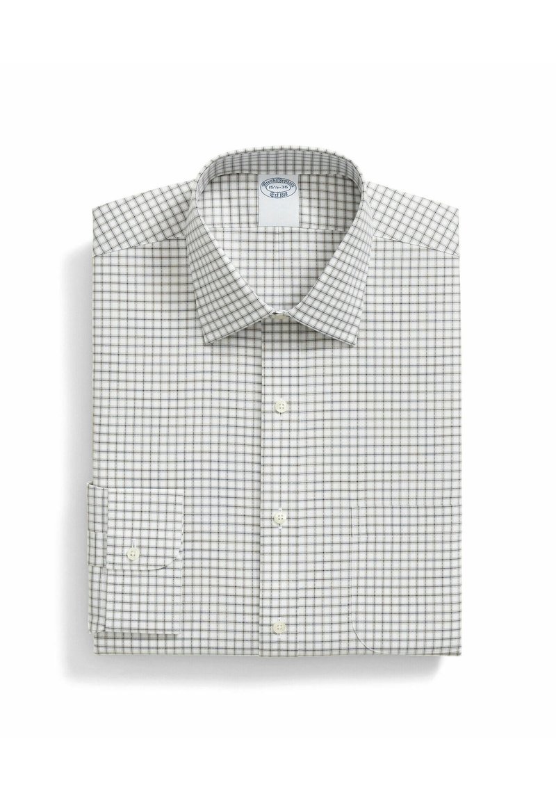 Camicia bianca con un piccolo motivo a quadretti in grigio e blu navy. Dotata di colletto, maniche lunghe e polsini bottonati, piegata in modo ordinato.