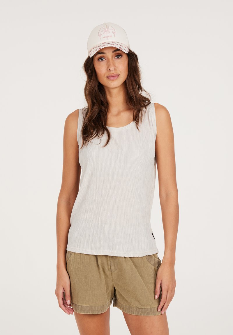 Hellgraues, geripptes Tanktop kombiniert mit olivgrünen, strukturierten Shorts. Die Kappe hat ein Palmenbaumdesign und pinke Akzente.