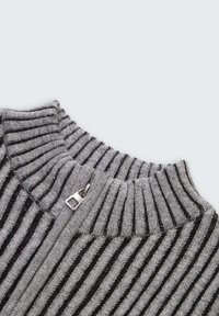 Grauer und schwarzer gestreifter Pullover mit einem gerippten Kragen und Reißverschluss, der eine weiche Textur und kontrastierende horizontale Muster aufweist.
