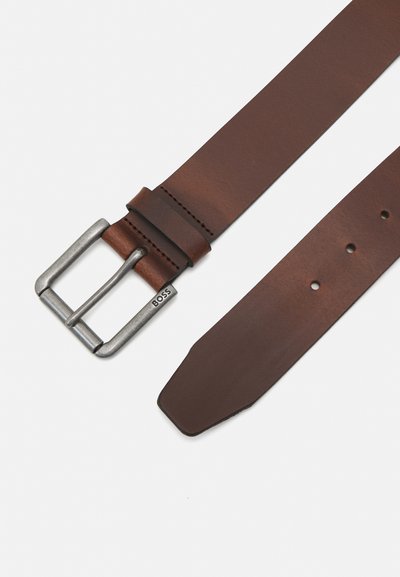 Ceinture en cuir marron avec une boucle en métal argenté. La ceinture présente une texture lisse, une forme droite et cinq trous ajustables.