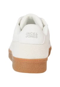 White sneaker with a textured heel, featuring the "JACK & JONES" logo. Rubber sole in a tan color, offering a clean and simple design.
