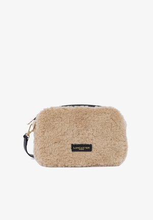 Borsa a tracolla in pelliccia sintetica beige con dettagli in pelle nera e hardware dorato. Presenta una chiusura con zip e un'etichetta del marchio in rilievo.