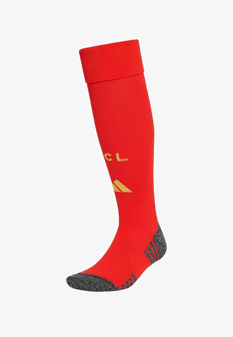 Chaussette de sport rouge montante jusqu'au genou avec orteil et talon renforcés gris, avec logo et lettres jaunes sur la zone du mollet.