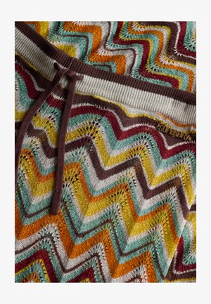 Mønstret strikstof i flere farver med et zigzag-mønster i orange, gul, teal, brun og hvid. Blød tekstur med ribbet talje og snoretræk.