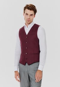 Bordowy kamizelka z pięcioma guzikami, klapą w kształcie prostokąta i boczną kieszenią, noszona z białą koszulą i szarymi spodniami w paski. Gładka tekstura materiału.