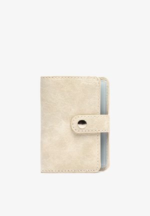 Compact beige leather cardholder wallet with snap button closure and visible transparent card slot inside.