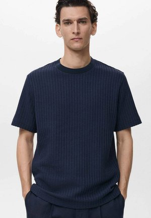 Navy blue ribbed knit t-shirt with short sleeves, round neckline, and relaxed fit. Subtle texture adds depth to the design.