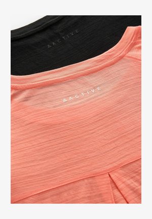 Dvě sportovní trička, jedno v jemné korálové a druhé v černé barvě, s hladkým povrchem a logem "ACTIVE" na zadním výstřihu.